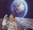 8岁的伊丽莎白·蒂尔森戴上宇航员手套，在自拍亭向家人挥手. 大卫·B. 霍林/ ODU