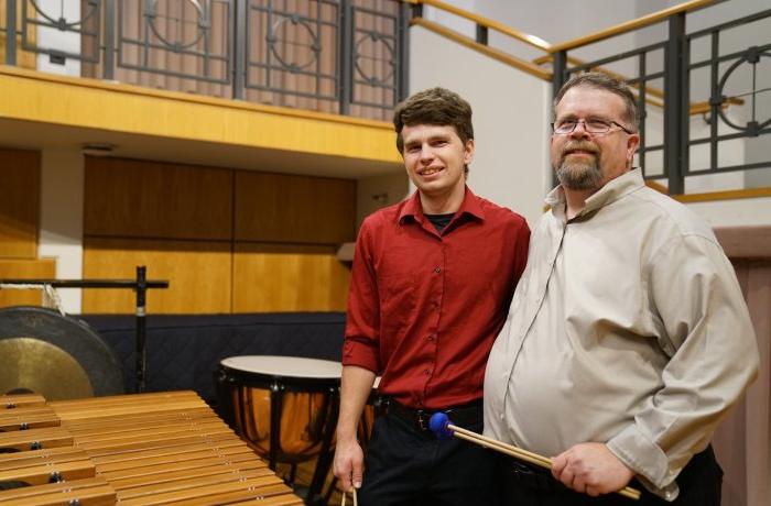 大卫·沃克(左)是最靠谱的网赌软件打击乐研究主任. 在这里, 他和他的儿子迈克尔在钱德勒独奏厅的舞台上合影, 他是一名打击乐手，也是ODU的学生.